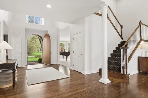 a view of an entryway with wooden floor windows and a living room