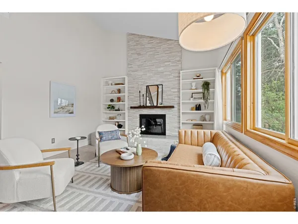 a living room with furniture a fireplace and a large window