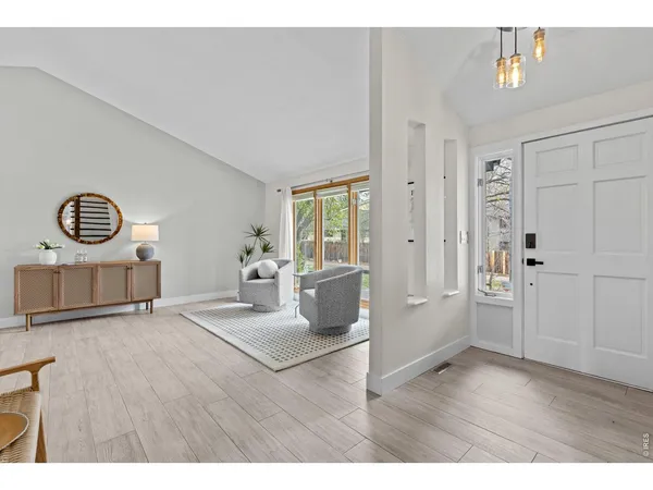 a view of a livingroom with wooden floor and furniture