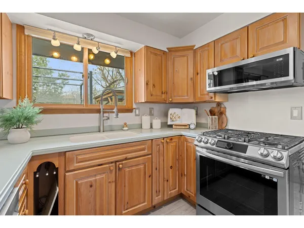 a kitchen with stainless steel appliances a stove a microwave a sink and cabinets