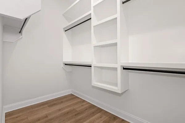 a view of walk in closet with empty racks