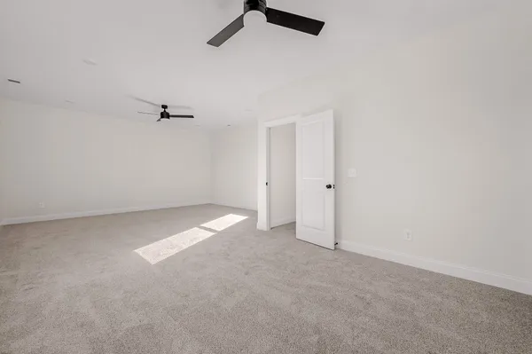 an empty room with a ceiling fan and window
