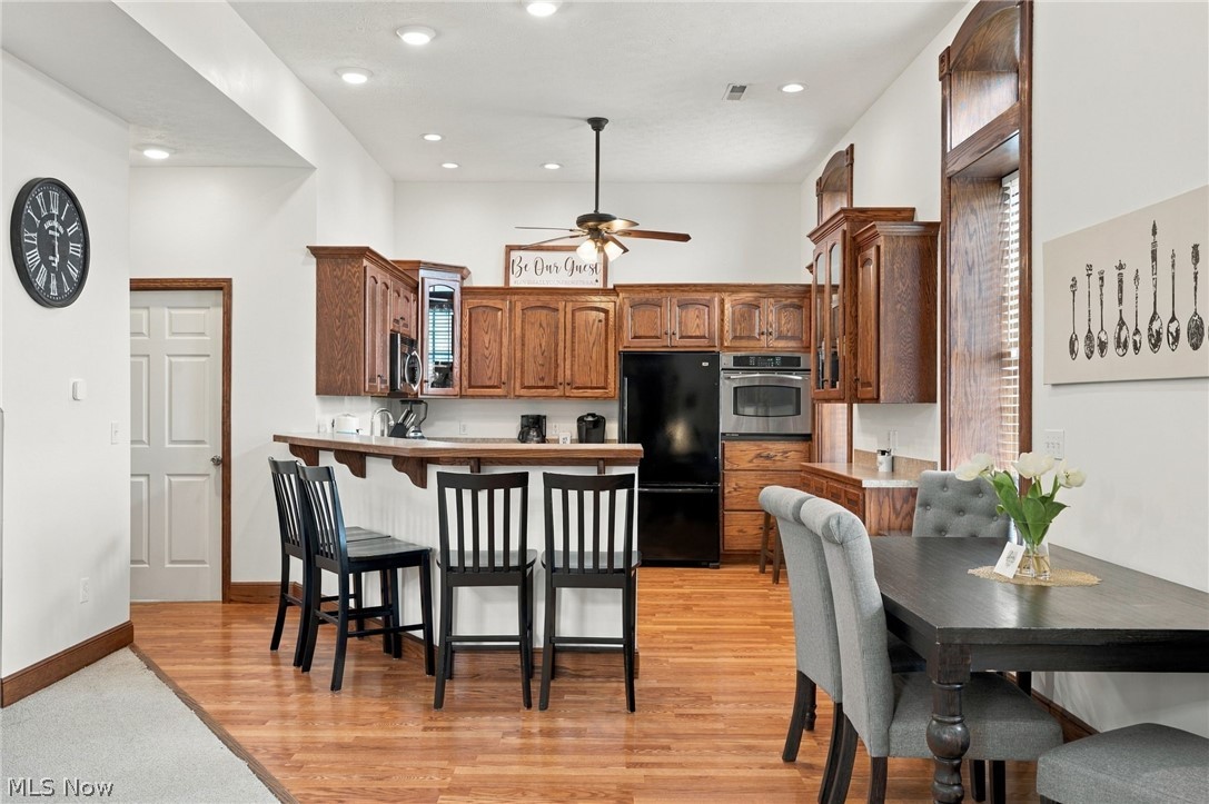 42764 Russia Road Elyria, OH 44035 - Photo 11 of 50 Open-concept kitchen with wood-finish flooring, recessed lighting, wood cabinetry, and a built-in microwave