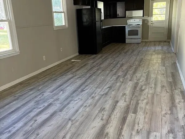 a kitchen with granite countertop a refrigerator and cabinets