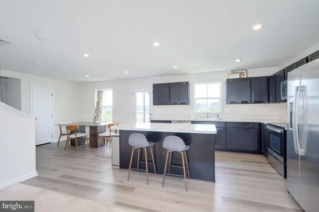 a kitchen with a sink and a stove top oven with wooden floor