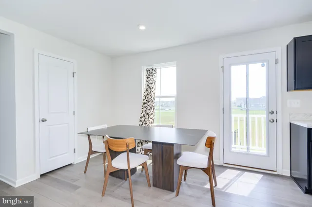 a living room with furniture a dining table and chairs with kitchen view