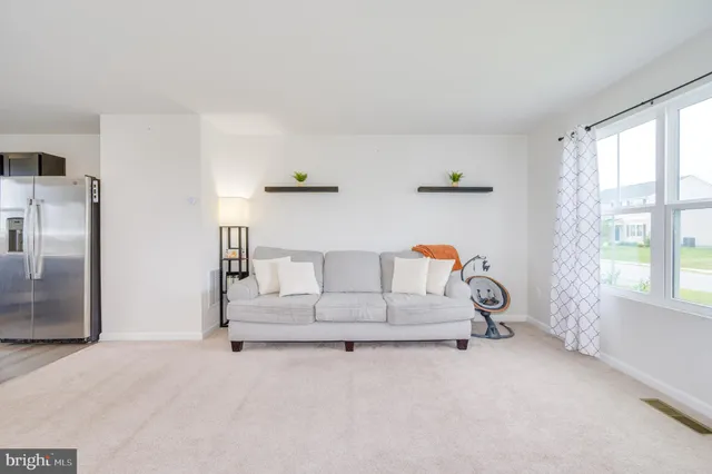 a white bed sitting in a room next to a window