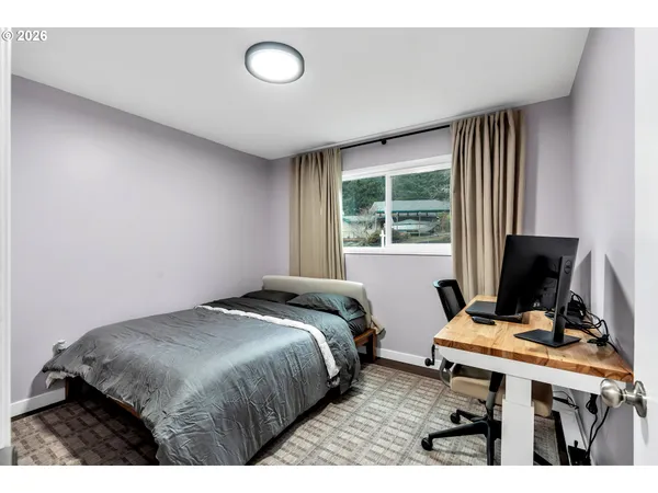 a bedroom with a bed and a computer on a desk