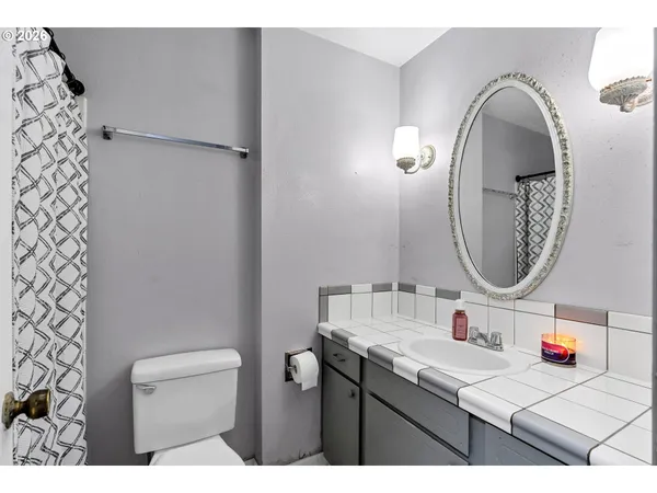 a bathroom with a sink vanity mirror and toilet