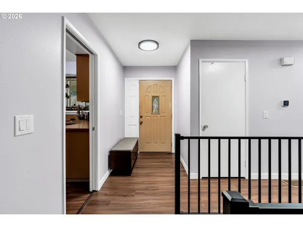 a view of a hallway with wooden floor and staircase