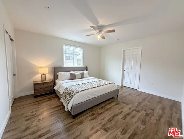 a bedroom with a bed and wooden floor