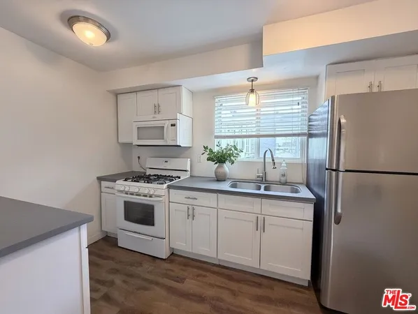 a kitchen with white cabinets and white appliances