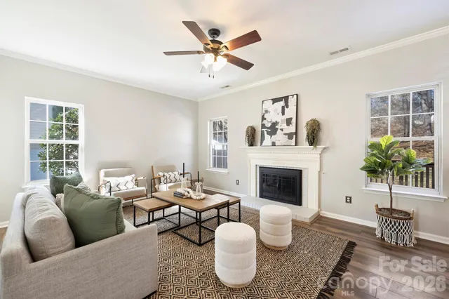 a living room with furniture kitchen view and a chandelier