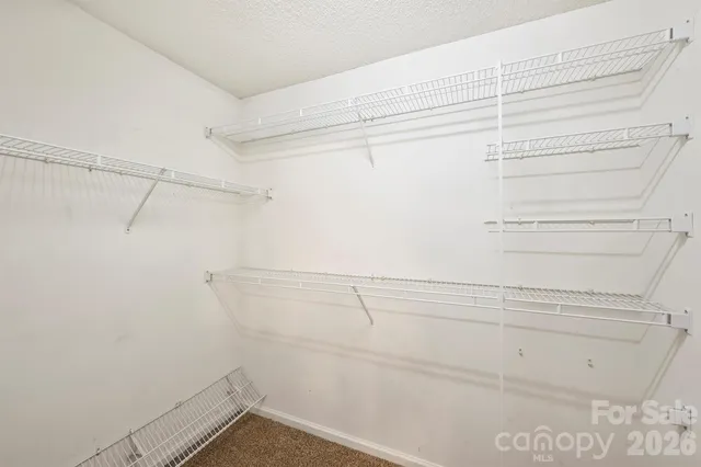 an empty room with windows and ceiling fan