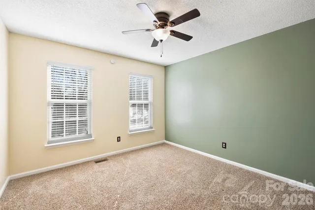an empty room with closet and chandelier fan