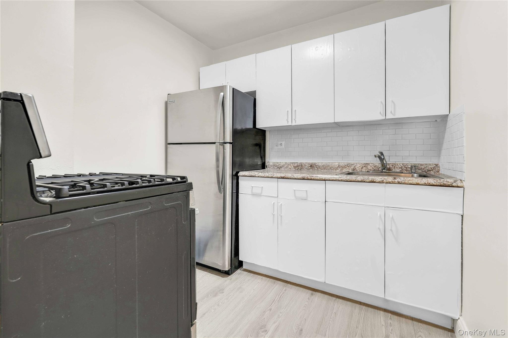 34-20 Parsons Boulevard, Unit 4W Queens, NY 11354 - Photo 13 of 17 a kitchen with appliances a sink and a stove