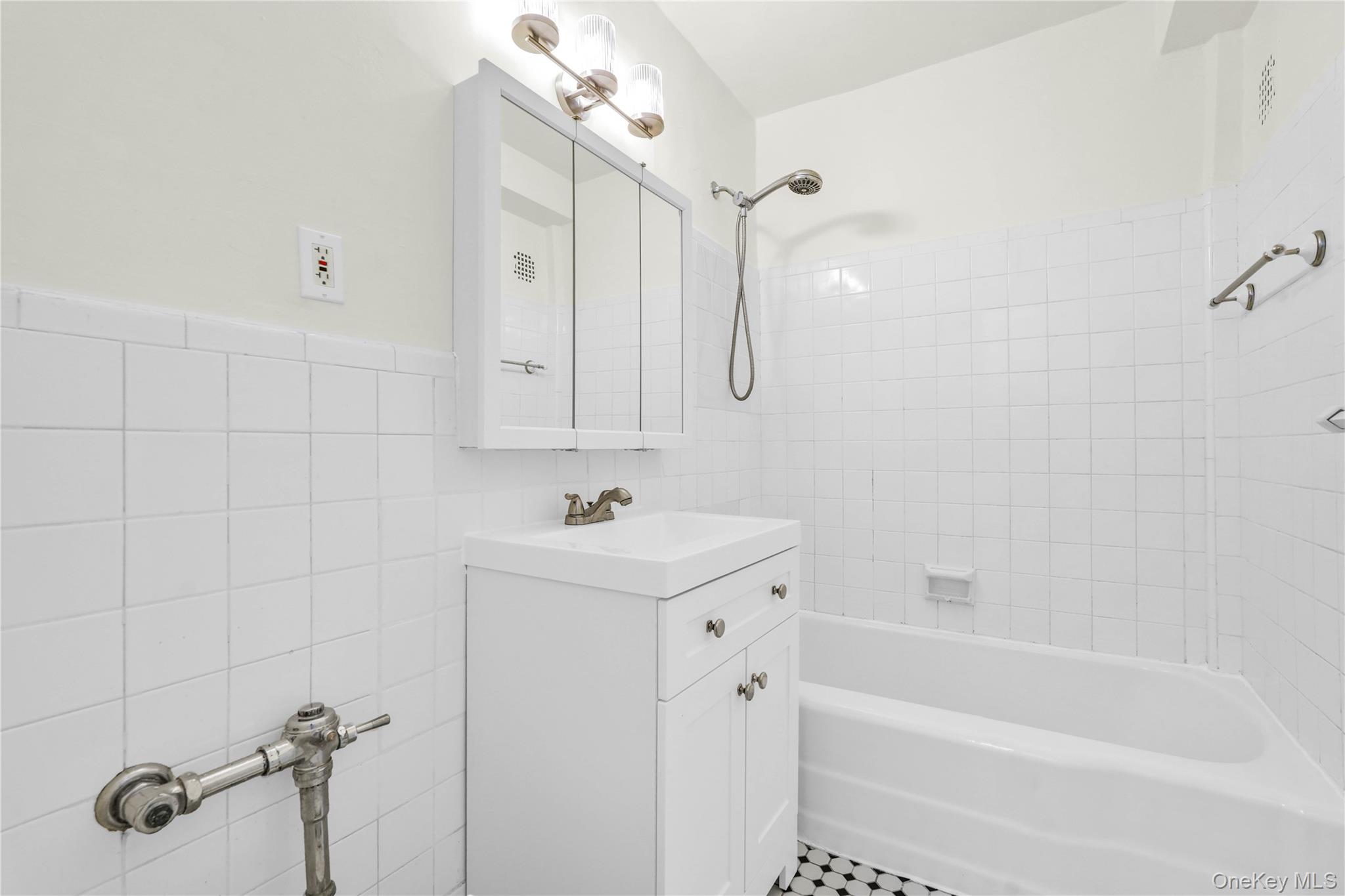 34-20 Parsons Boulevard, Unit 4W Queens, NY 11354 - Photo 15 of 17 a bathroom with a bathtub a shower a sink and vanity