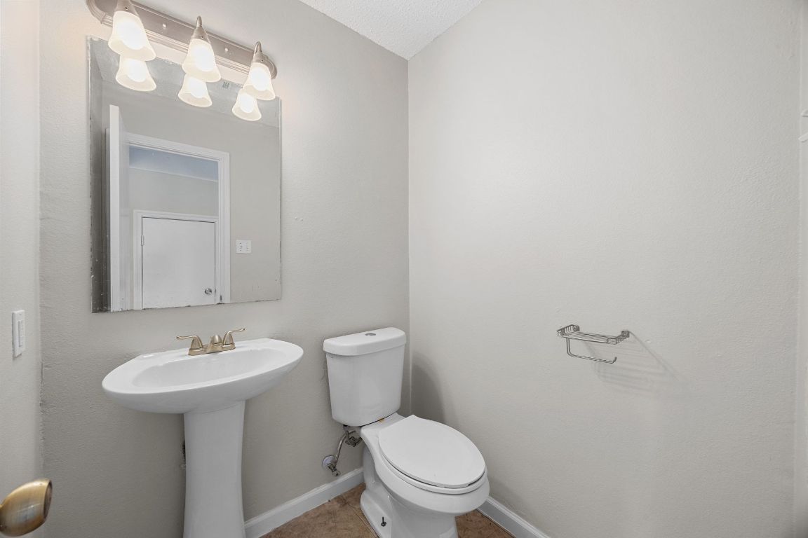 1326 Lakeside Loop Round Rock, TX 78665 - Photo 12 of 29 a white toilet sitting next to a bathroom sink