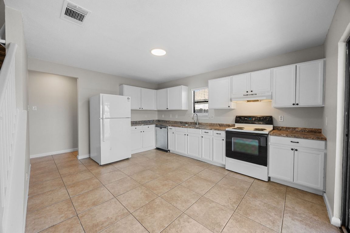 1326 Lakeside Loop Round Rock, TX 78665 - Photo 8 of 29 a kitchen with cabinets and white stainless steel appliances