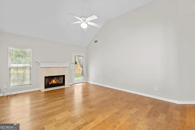 an empty room with windows and fireplace