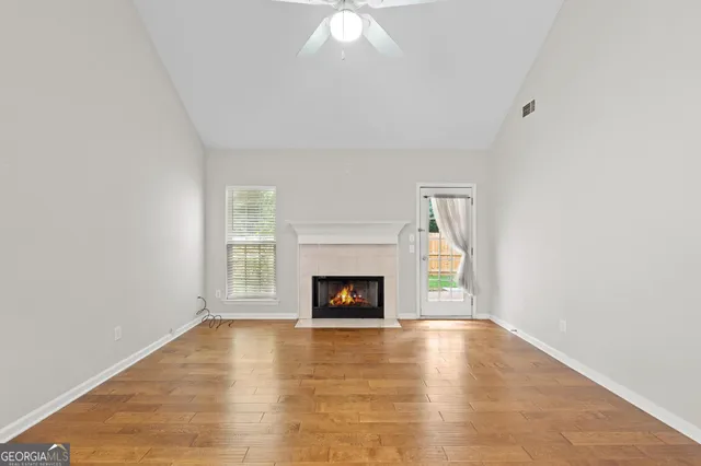 a view of an empty room with a fireplace and a window