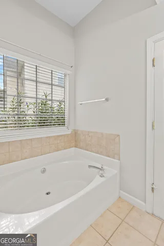 a bathroom with a glass shower door and a window