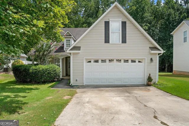 a view of a house with yard and garage
