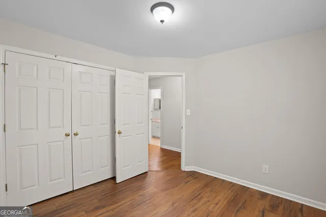 a view of an empty room with wooden floor