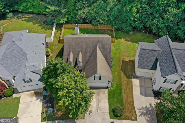 a aerial view of a house with a yard and large tree