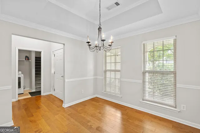 a view of a livingroom with a chandelier fan and windows