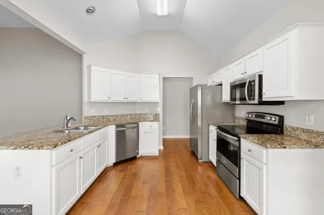 a kitchen with a sink stove microwave and refrigerator