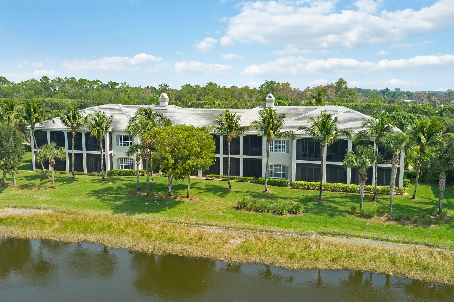 9263 Museo Circle, Unit 202 Naples, FL 34114 - Photo 28 of 45 a view of a house with a big yard and large trees