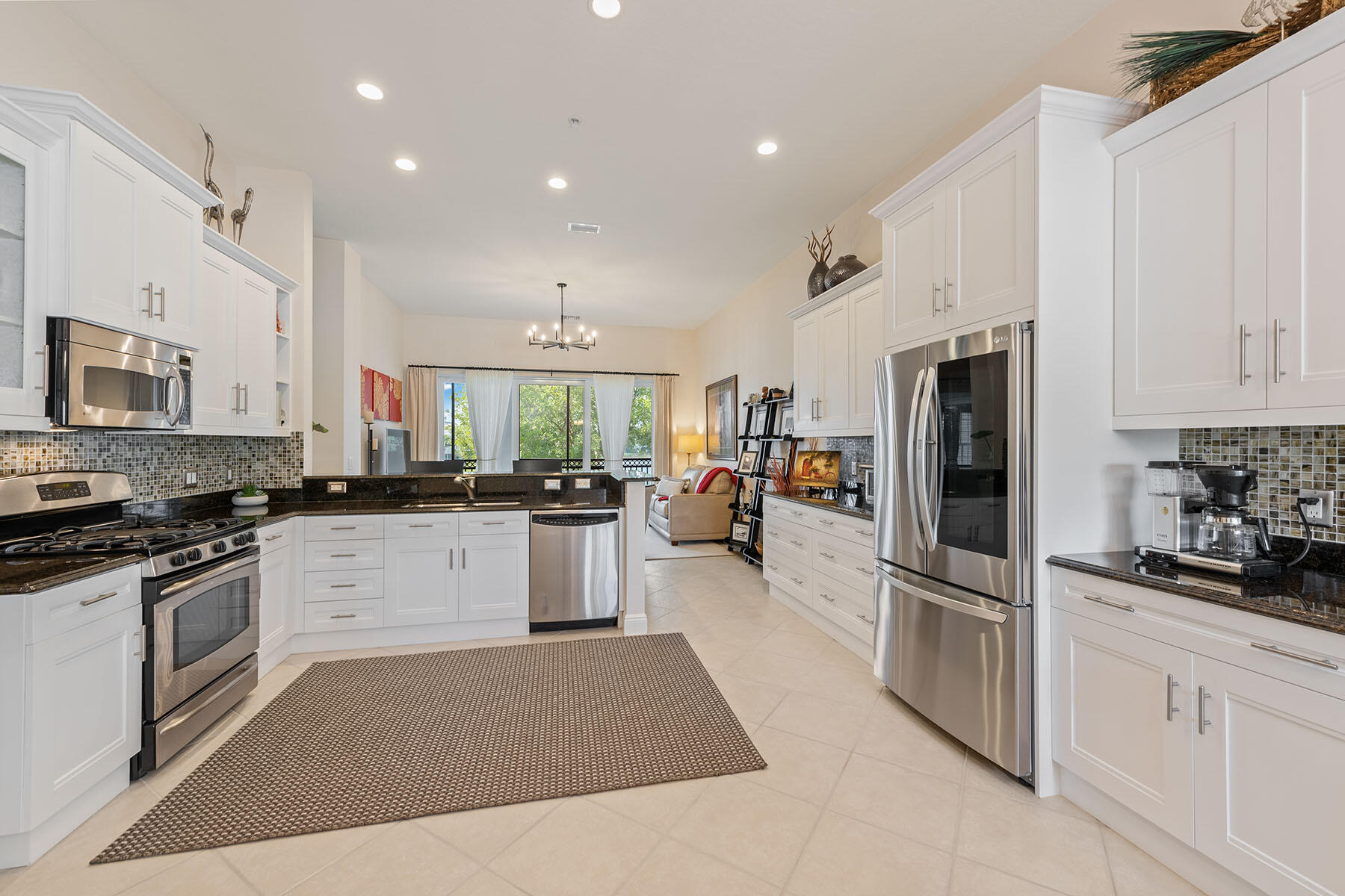 9263 Museo Circle, Unit 202 Naples, FL 34114 - Photo 7 of 45 a kitchen with white cabinets and stainless steel appliances