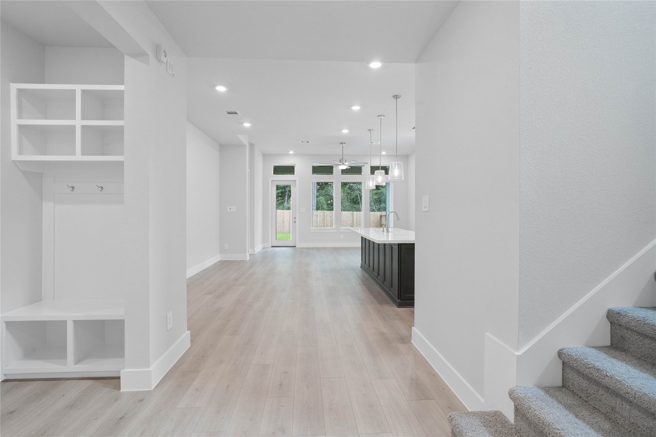 2035 Frst Strm Way Conroe, TX 77304 - Photo 11 of 45 Once inside, the home unfolds into a magnificent open-concept layout, highlighting an integrated mudroom station, a striking island kitchen, and a soaring staircase.