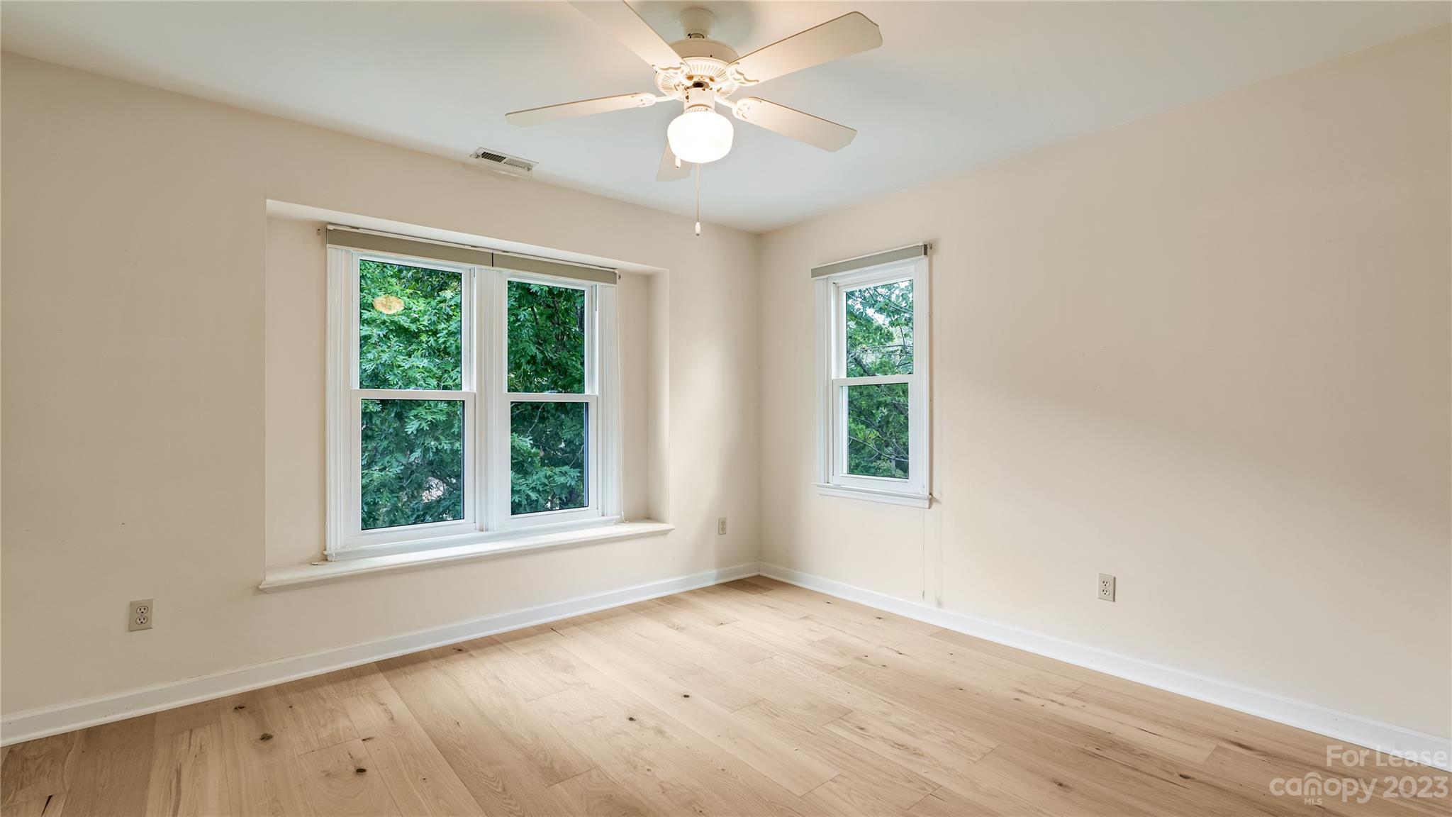 29025 Beaver Run Tega Cay, SC 29708 - Photo 23 of 40 an empty room with wooden floor ceiling fan and windows