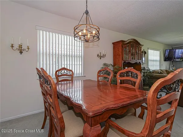 a dining room with furniture a chandelier and wooden floor