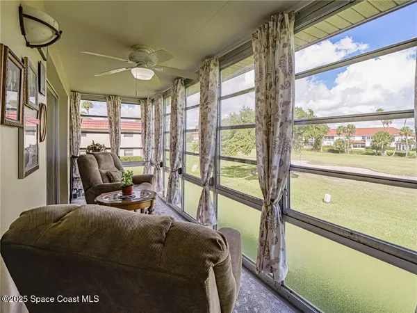 a living room with furniture and a floor to ceiling window