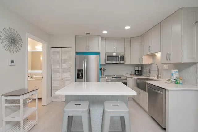 a kitchen with white cabinets and stainless steel appliances