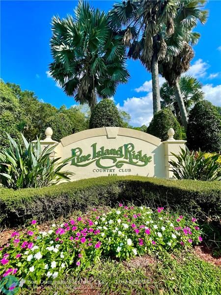 9495 Evergreen Place, Unit 405 Davie, FL 33324 - Photo 12 of 17 a sign that is in front of flowers