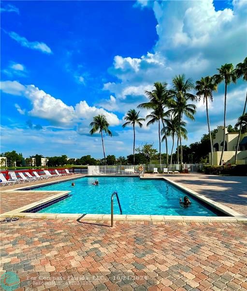 9495 Evergreen Place, Unit 405 Davie, FL 33324 - Photo 15 of 17 a view of a swimming pool and lounge chairs