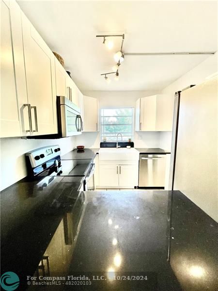 9495 Evergreen Place, Unit 405 Davie, FL 33324 - Photo 4 of 17 a kitchen with stainless steel appliances granite countertop a sink stove and cabinets