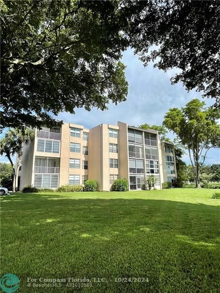 9495 Evergreen Place, Unit 405 Davie, FL 33324 - Photo 9 of 17 a front view of a house with a garden