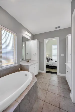 a spacious bathroom with a tub and mirror