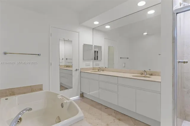 a bathroom with a tub sink and mirror