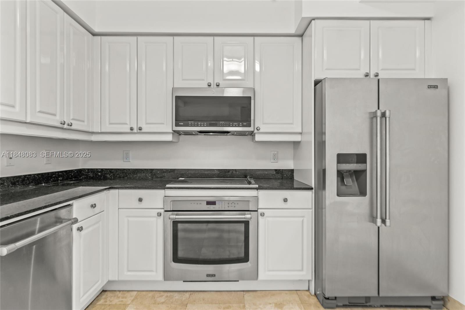 703 Crandon Boulevard, Unit PH3 Key Biscayne, FL 33149 - Photo 23 of 40 a kitchen with white cabinets and stainless steel appliances