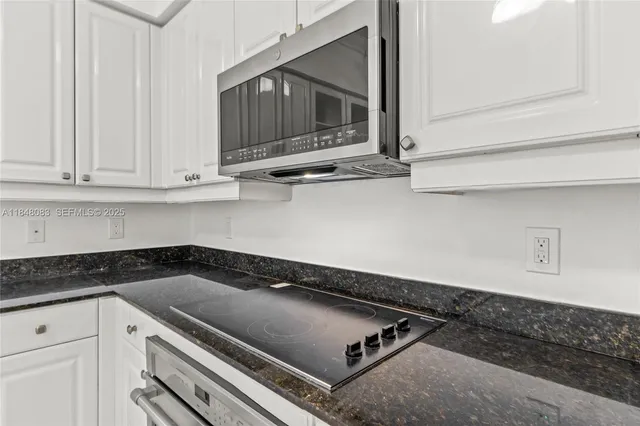 a kitchen with granite countertop a stove and a microwave
