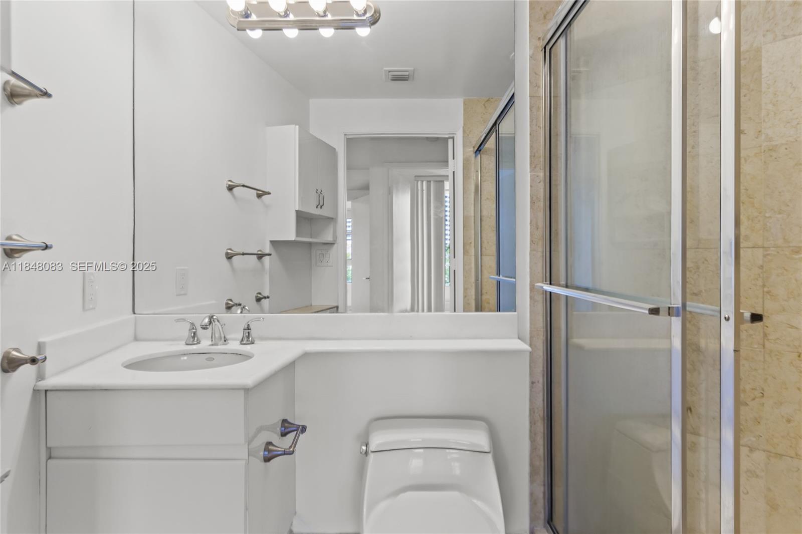 703 Crandon Boulevard, Unit PH3 Key Biscayne, FL 33149 - Photo 26 of 40 a bathroom with a sink a toilet and a mirror