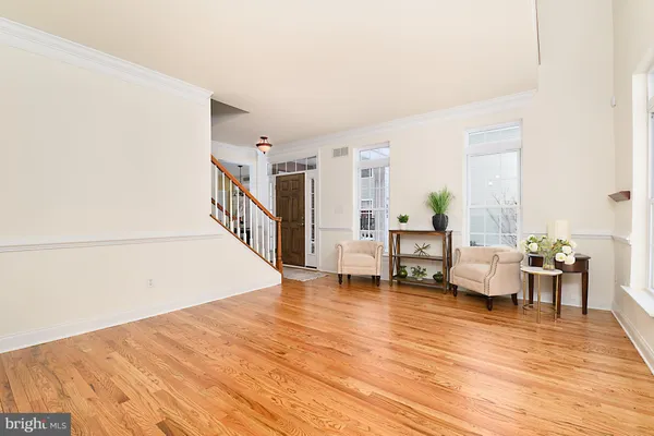 a dining room with furniture a chandelier and wooden floor