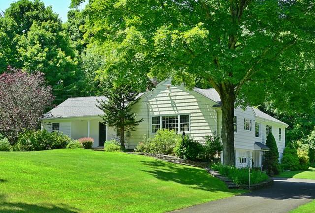 a front view of a house with a yard and trees