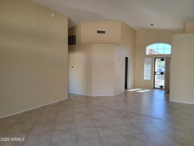 a view of a hallway with wooden floor and a living room
